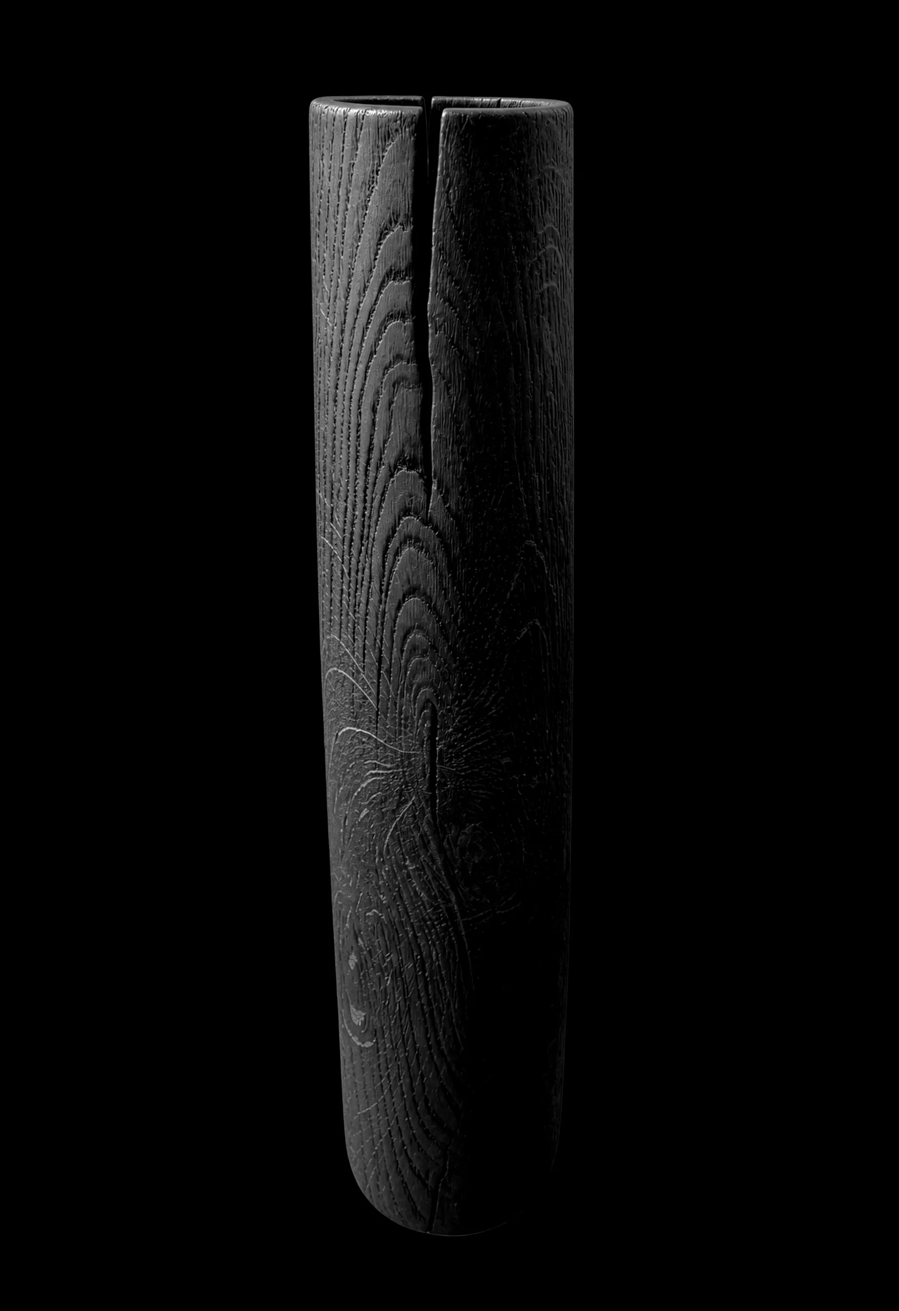 Tall, slender charred oak vase with a deep split and visible grain against a black background
